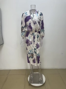 Detailed view of V-neckline and abstract floral ink print on long sleeve white dress