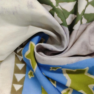 Gros plan détaillé d'un tissu imprimé avec des motifs d'étoiles et des tons bleus et verts