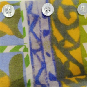 Gros plan sur les boutons blancs et le tissu à imprimé géométrique coloré de la robe