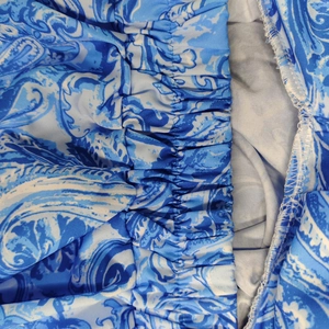 Dettaglio della vita elastica arricciata su un abito lungo con stampa paisley blu