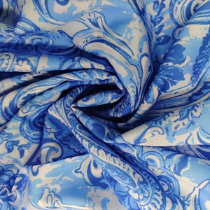 Dettaglio del tessuto con stampa paisley barocca blu, trama setosa e motivi vivaci