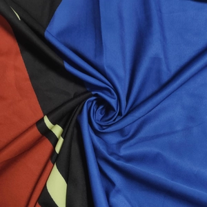 Close-up of geometric pattern print on soft fabric with deep blue and red curves