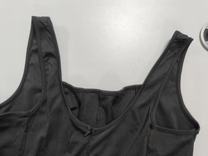 Détail de l'encolure de la robe noire sans manches avec fermeture éclair et texture