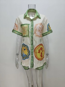 Dettaglio di una camicia a maniche corte con stampe di distintivi e bordi verdi decorati