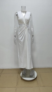 Detail of white sleeveless maxi dress featuring a deep V-neck and twisted cutout waist design