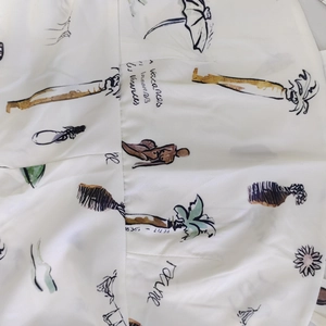Dettaglio del tessuto bianco con stampe di vacanze disegnate a mano e scritte francesi