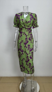 Detail of green floral wrap dress with V-neckline and puff sleeves showing fabric texture