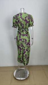 Detail view of the back of a green floral V-neck dress with puff sleeves and waist tie