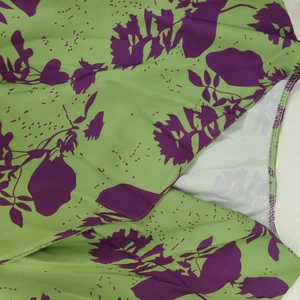 Detail of green floral fabric showing precision stitching and purple leaf pattern