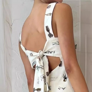 Abito aderente bianco a fiori con schiena scoperta e grande fiocco decorativo sul retro