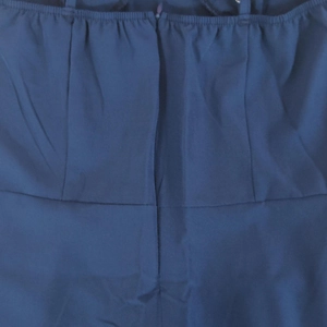 Detail view of the hidden back zipper and waist stitching on this navy blue A-line dress
