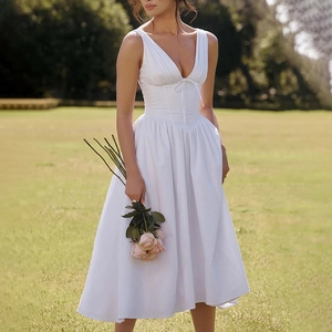 Detail of elegant V-neck floral print dress with corset-style waist and bow tie accent