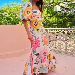 Detail view of sunflower print dress with square neck and puffed short sleeves