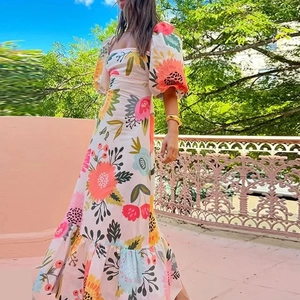 Detailed close-up of vibrant floral print and ruffled hem on an elegant A-line maxi dress