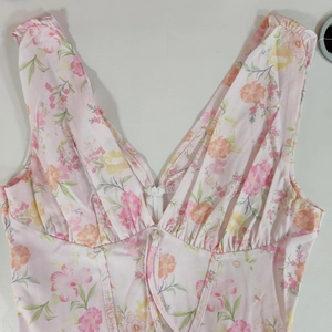 Detail of pink floral corset top featuring V-neck, front zipper and drawstring details