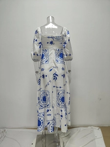 Detail of square neck and bubble sleeves on a white dress with blue solar patterns