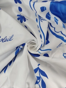 Detail of white fabric featuring blue Soleil print and abstract floral patterns