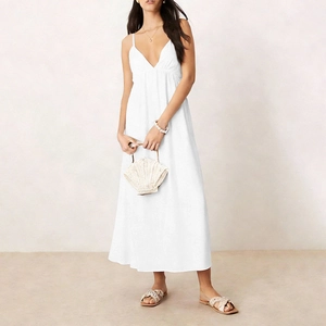 Detail of white V-neck backless maxi dress with a flowing A-line hem in resort style