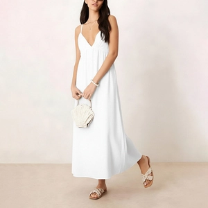 Full-body shot of a white V-neck maxi dress with thin straps and a flowing skirt