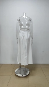 Detail view of white satin backless dress with elegant cross straps and glossy finish