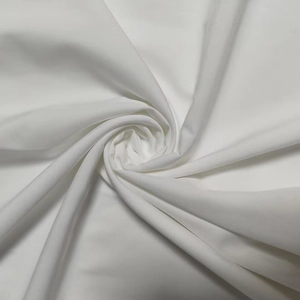 Detailed macro view of white twill fabric with soft drape and subtle glossy finish