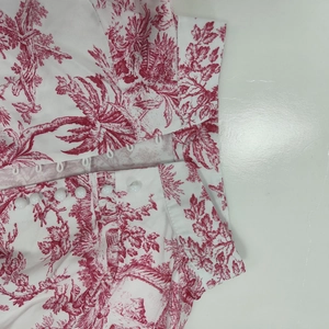 Détail de robe à imprimé Toile de Jouy rouge avec boutons de perles décoratifs