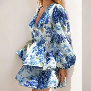 Detail of light blue floral dress with V-neck puff sleeves and layered ruffle hem