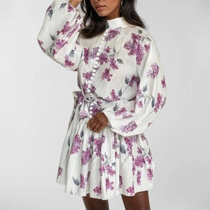 Detailed macro view of the purple floral print and natural linen fabric texture on dress