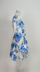 Detail of blue floral dress featuring puff sleeves and a layered ruffled mini skirt