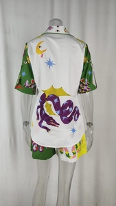 Rear view detail of casual set showing mythological dragon and sun prints on white fabric