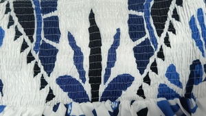 Dettaglio della stampa tropicale blu con tessuto elastico a punto smock su abito