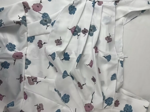Detail view of floral dress showing ruffles and white invisible zipper closure
