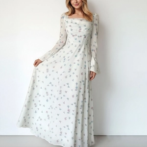 Detail of elegant floral dress with waist ruching and flared sleeves on white background