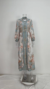 Détail d'une robe longue fleurie avec manches bouffantes, col en V et boutons rétro