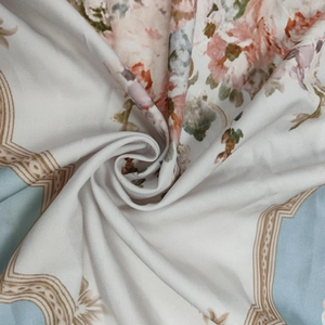 Dettaglio del tessuto con elegante stampa floreale, fiori rosa e bordo geometrico blu