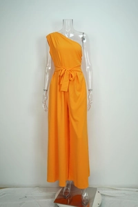 Close-up detail of a vibrant orange one-shoulder wide-leg jumpsuit with a waist tie
