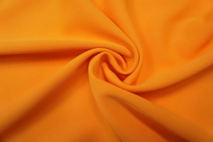 Detail macro shot of vibrant orange high-quality fabric texture for summer jumpsuit
