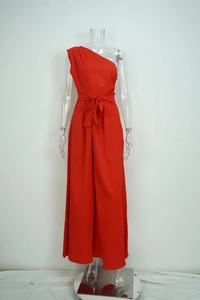 Detail of red one-shoulder wide-leg jumpsuit with waist tie and bow decoration