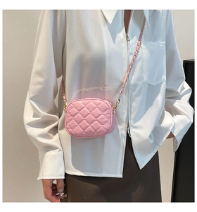 Gros plan sur un mini sac bandoulière rose matelassé avec des détails de chaîne dorée