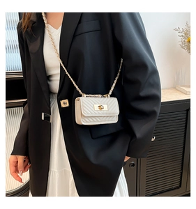 Detail of white quilted mini crossbody bag with gold twist lock and chain strap on model