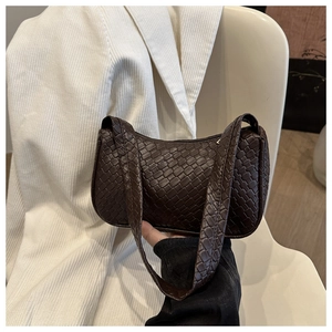 Vue détaillée de la texture tissée marron foncé sur un sac baguette minimaliste