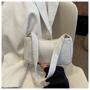 Gros plan sur la texture tissée et le cuir du sac baguette blanc élégant pour femme