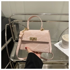Detail of pink marble textured crossbody bag with gold metallic twist lock and handle