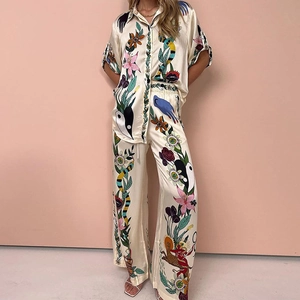 Elegant off-white two-piece set featuring short-sleeve printed shirt and wide-leg trousers