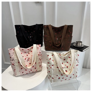 Detalle de cuatro bolsos tote de pana con estampado de fresas y bolsillos con botón a presión