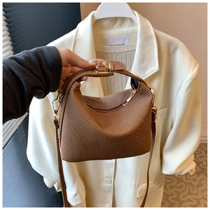Detail van de bruine crossbodytas met wafelstructuur en gouden metalen sluiting