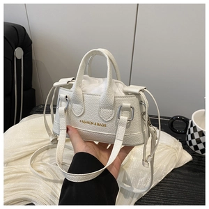 Detail view of white lychee pattern mini handbag with gold fashion text and drawstring inner
