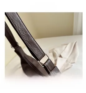 Detail of dark brown lychee texture leather shoulder bag with silver square metal ring