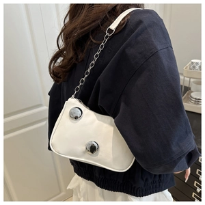 Detail of white leather underarm bag with silver sphere studs and chain shoulder strap