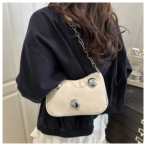 Detailed back view of a beige leather shoulder bag with metallic dome studs and chain strap